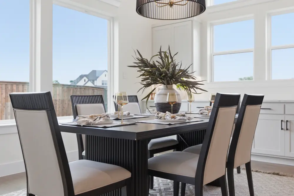 Breakfast nook with a dark wood table under a woven pendant