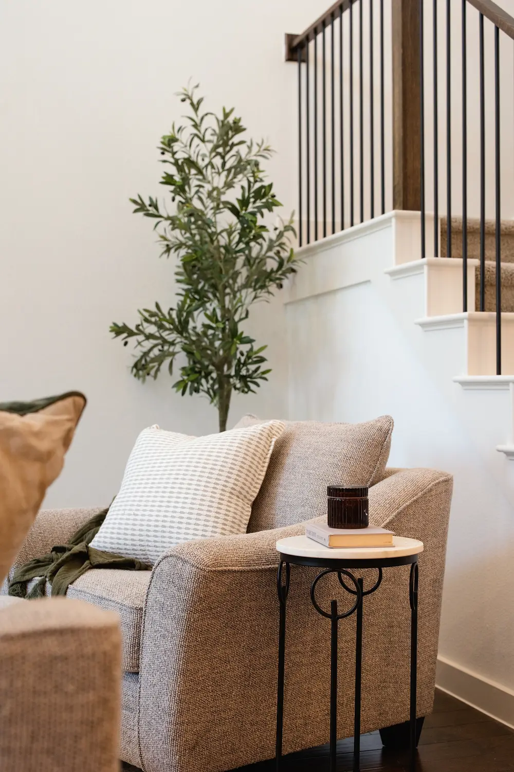 Reading chair beside a staircase with an olive tree