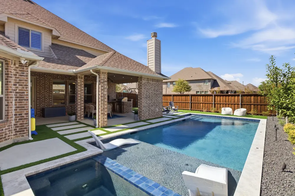 Backyard pool with a covered patio and a stone fireplace